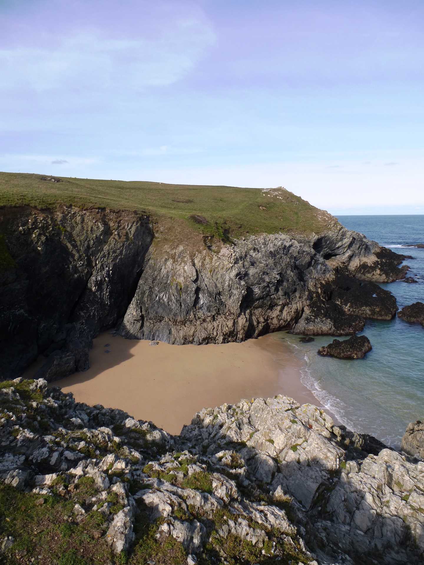A clifftop view of the bay with the ocean in view